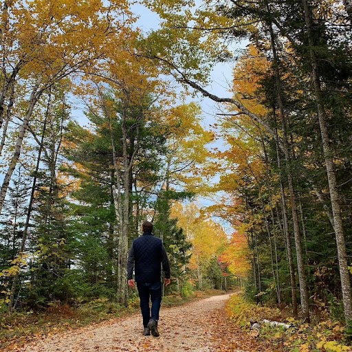 Anthony Iracki Walks down a fall-colored path with his original Kromer Cap on.