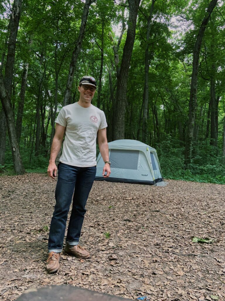 Paul Wheatley, @cuffcheckdenim posing by his campsite.