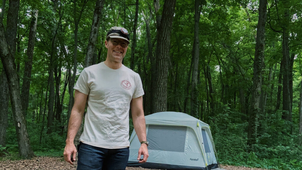 paul wheatley in the woods by a camping tent