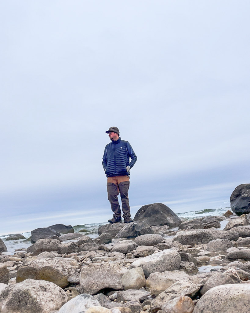 KC Blog KC Blog When is A Hat More Than Just a Hat Anthony standing on a rocky beach with a stormy Kromer hat