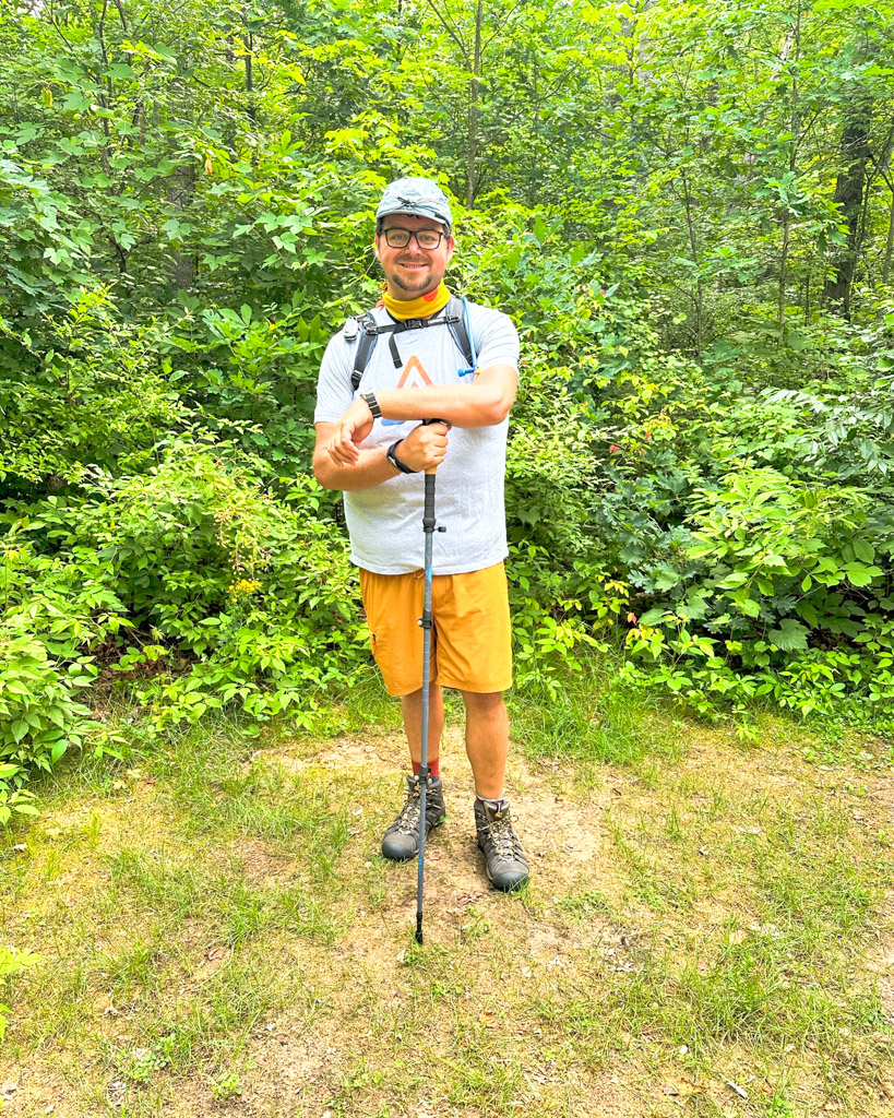 KC Blog KC Blog When is A Hat More Than Just a Hat Anthony standing in a trail with hiking gear and a stormy kromer