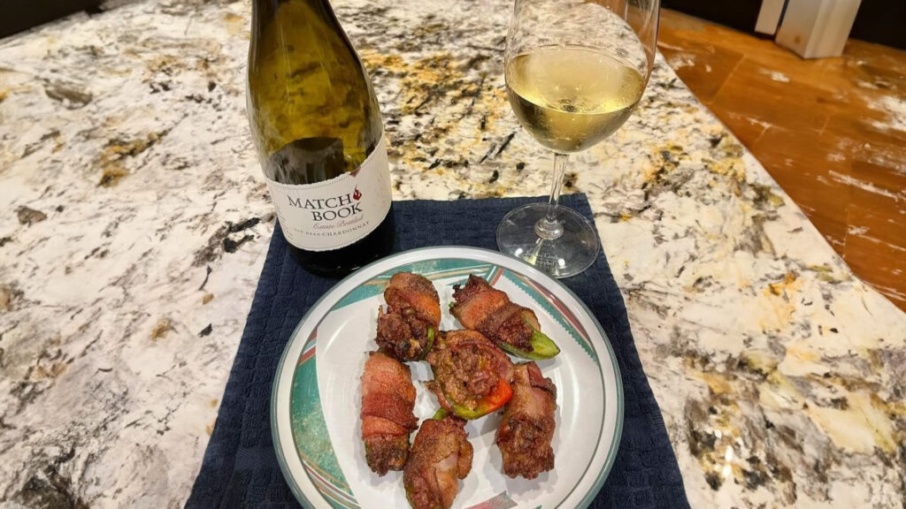 KC Wood Duck Poppers Blog a bottle of wine and a glass sitting on a counter with a plate of duck poppers