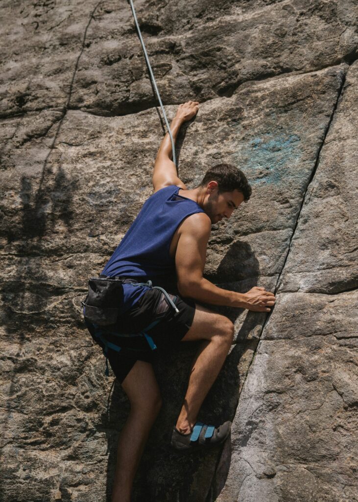 a guy rock climbing on the side of a cliff