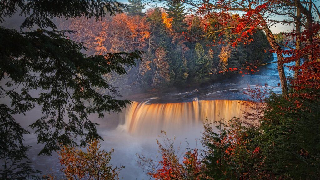 tahquamenon falls in northern michigan during the fall with leaves changing colors