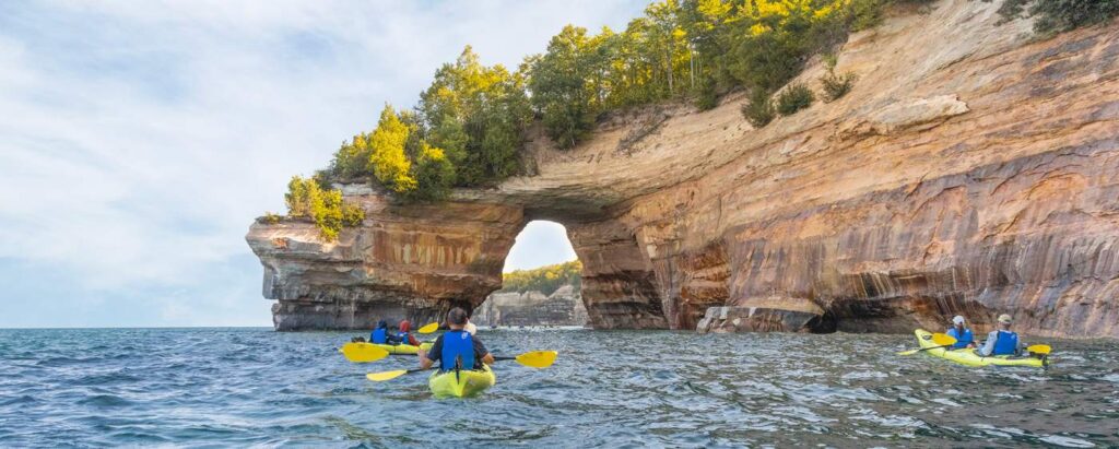 kayakers rowing up to pictured rocks in northern michigan
