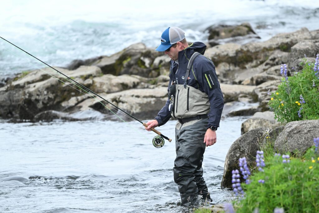 A man near the lake getting ready to go fly fishing