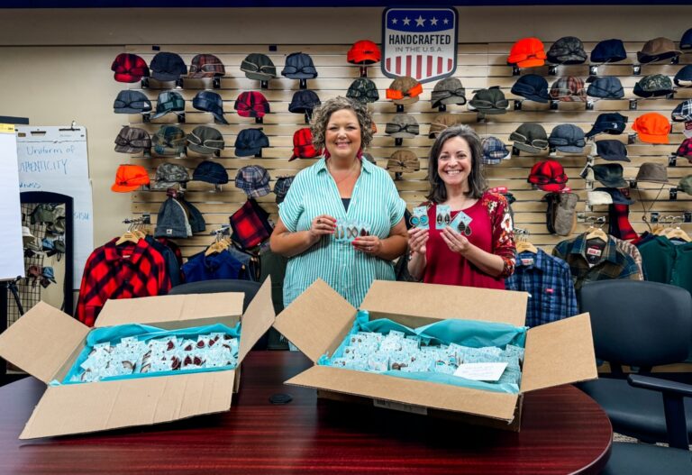 Kristen Rice, owner of Fleece & Fancy, poses with the Stormy Kromer earrings alongside Gina Thorsen, the CEO of Stormy Kromer