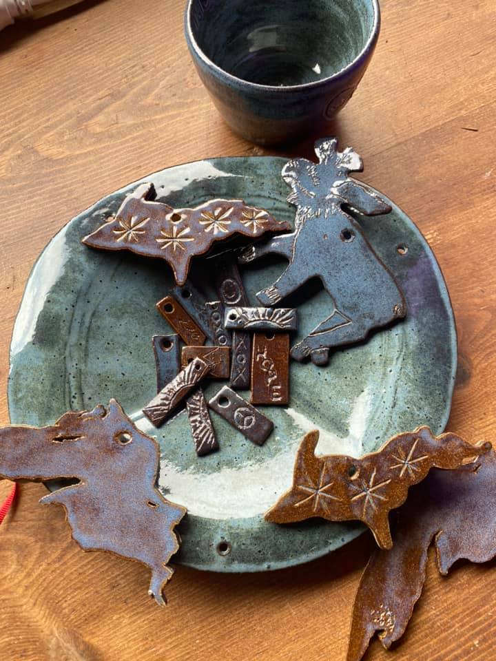 Ceramic moose, Michigan, and other shapes rest on a plate.