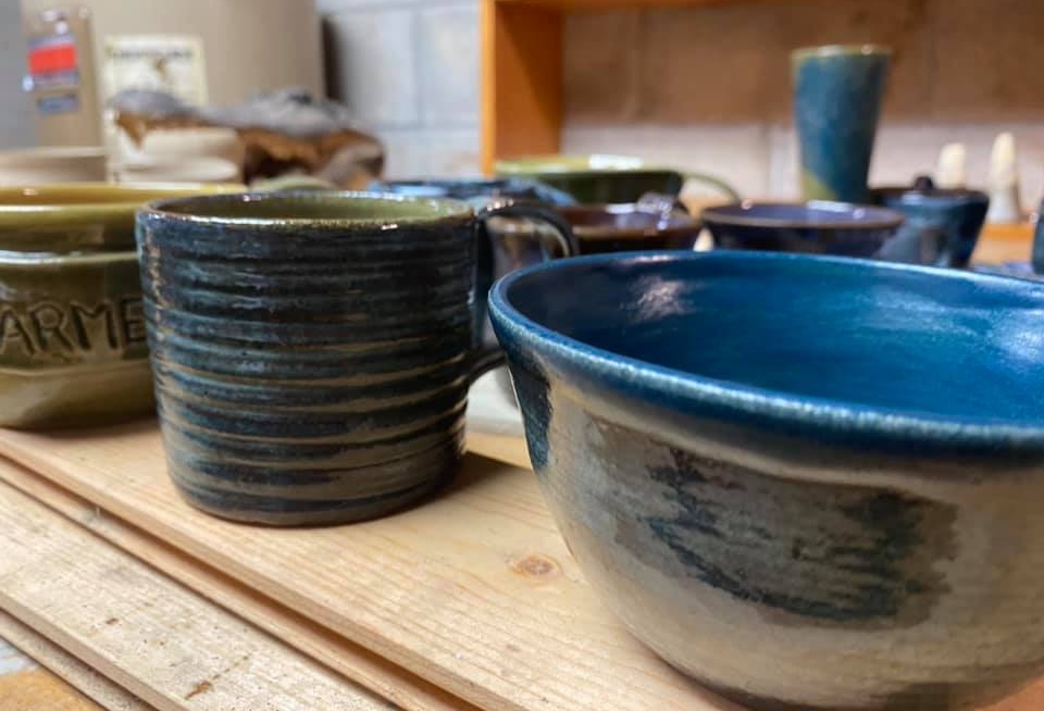 Handmade pottery rests on the table at SnowDance Pottery